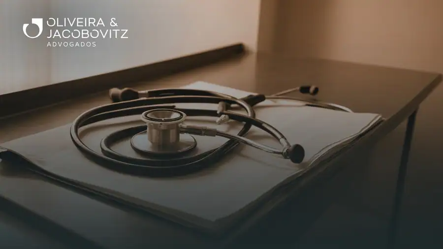 Hands signing a contract on a desk with a stethoscope and hospital billing reports